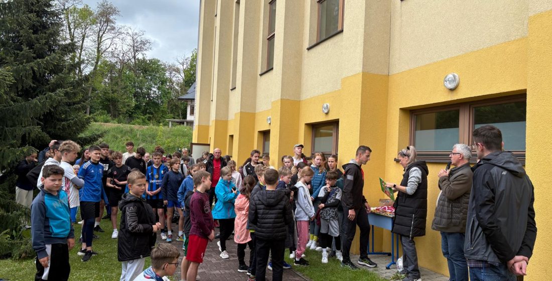 zdjęcie przedstawia uczestników biegu przed wręczeniem medali