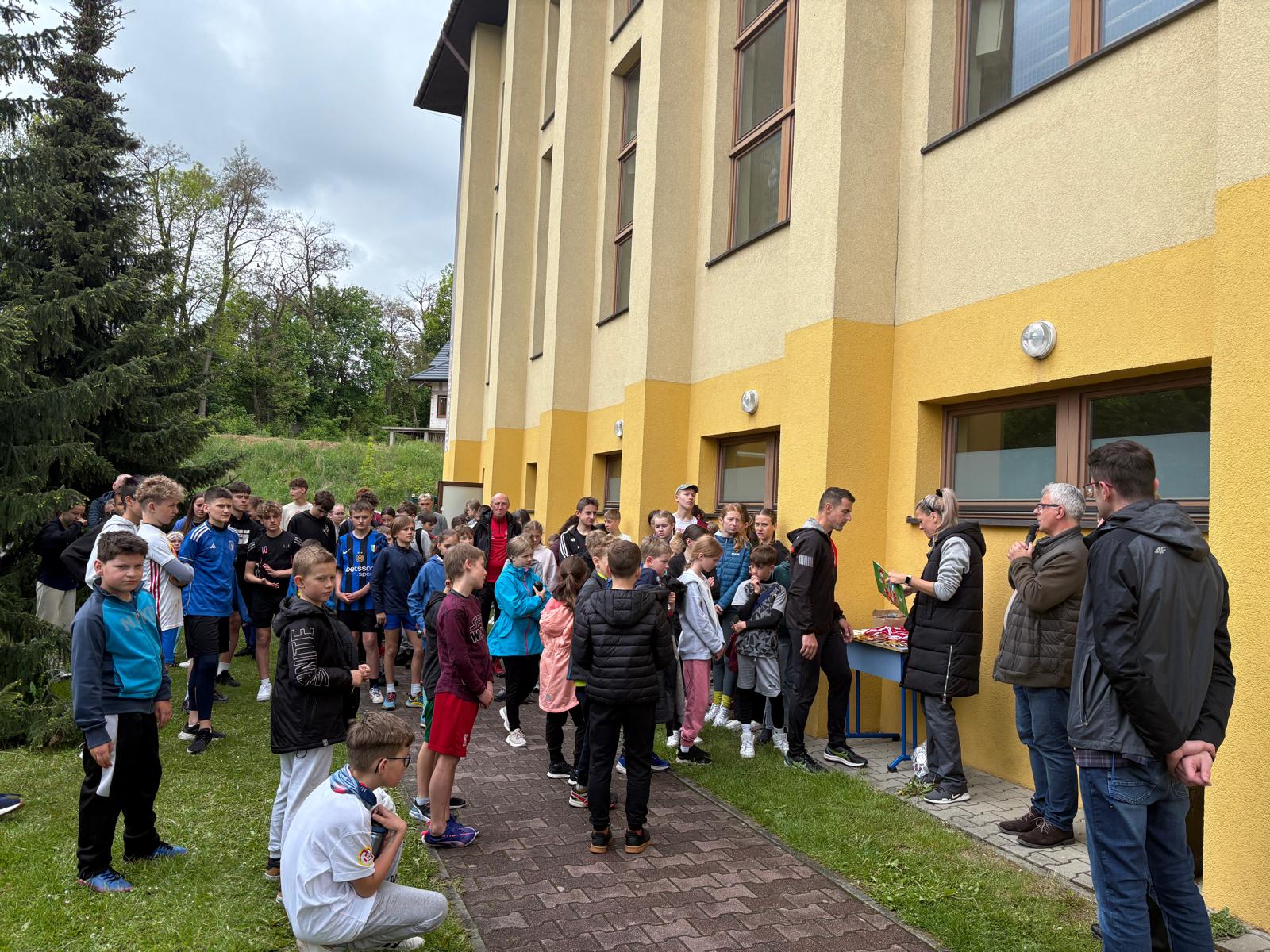 zdjęcie przedstawia uczestników biegu przed wręczeniem medali